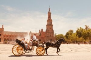 a couple of people riding on the back of a horse drawn carriage